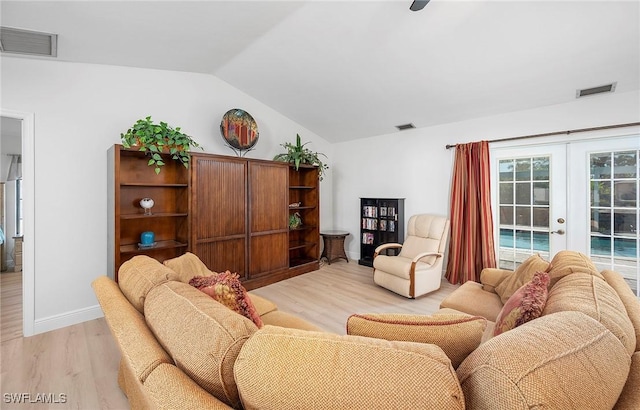 living room with lofted ceiling, french doors, and light hardwood / wood-style floors