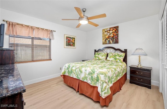 bedroom with ceiling fan, light hardwood / wood-style flooring, and a closet