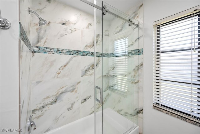 bathroom featuring enclosed tub / shower combo and a wealth of natural light