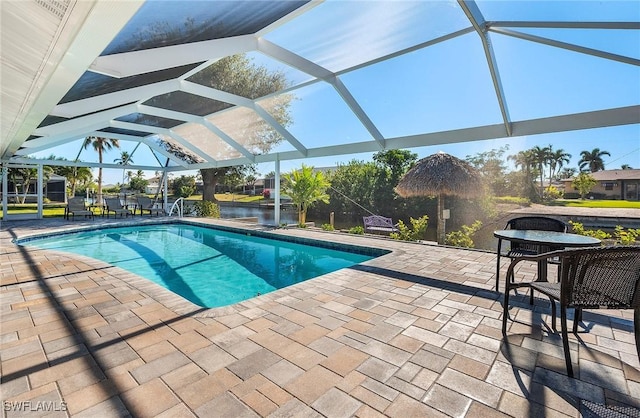 view of swimming pool with a lanai, a patio, and a water view