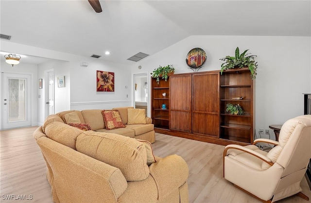 living room featuring lofted ceiling and light hardwood / wood-style floors