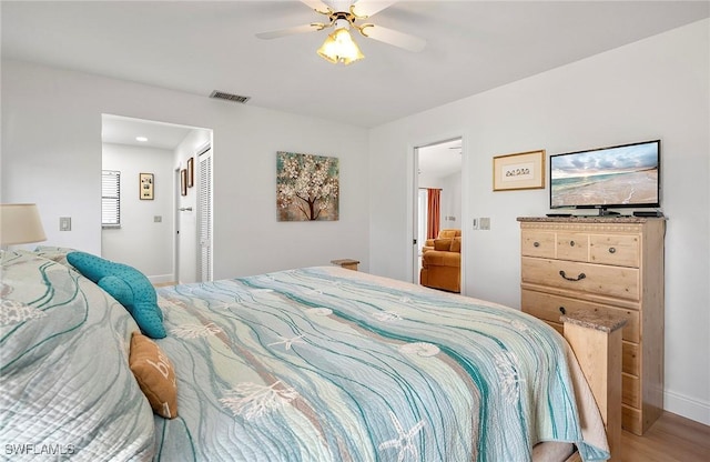 bedroom with wood-type flooring, ceiling fan, and a closet