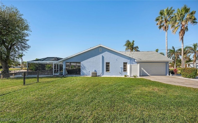 view of front of home featuring a lanai, central air condition unit, a front lawn, and a garage