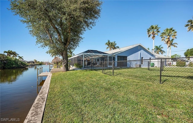 view of yard featuring a lanai, a dock, and a water view