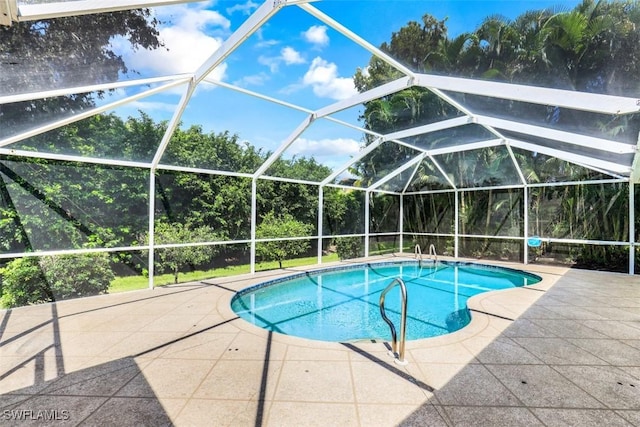 view of pool featuring glass enclosure and a patio