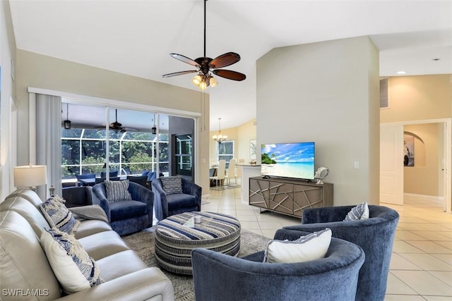 living room featuring lofted ceiling, ceiling fan with notable chandelier, and light tile patterned floors