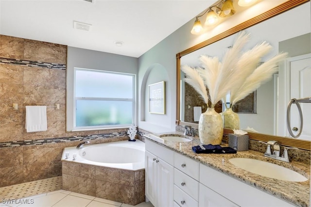 bathroom with vanity, tile patterned floors, and tiled bath