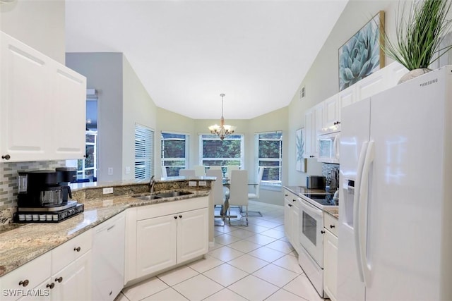 kitchen featuring white appliances, hanging light fixtures, lofted ceiling, white cabinetry, and sink