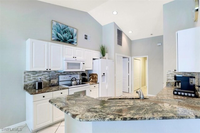 kitchen featuring sink, white appliances, white cabinetry, and kitchen peninsula