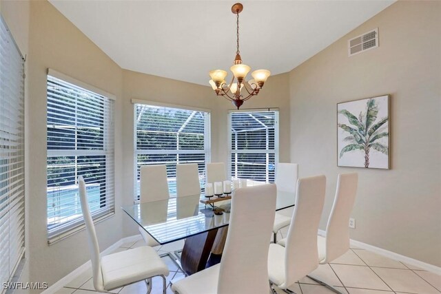 tiled dining area with a chandelier and vaulted ceiling