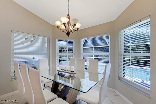 dining room featuring lofted ceiling, a healthy amount of sunlight, light tile patterned floors, and a notable chandelier