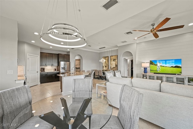 living room featuring sink, ceiling fan with notable chandelier, and light tile patterned floors