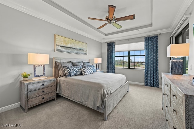 carpeted bedroom featuring ornamental molding, ceiling fan, and a tray ceiling