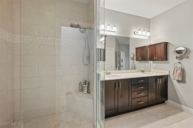 bathroom featuring tiled shower and vanity