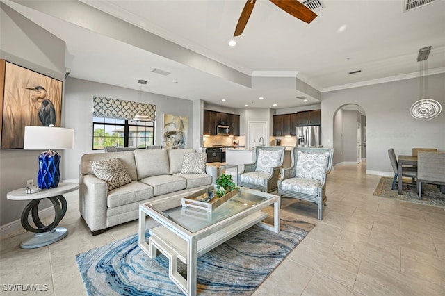 living room featuring ceiling fan and crown molding