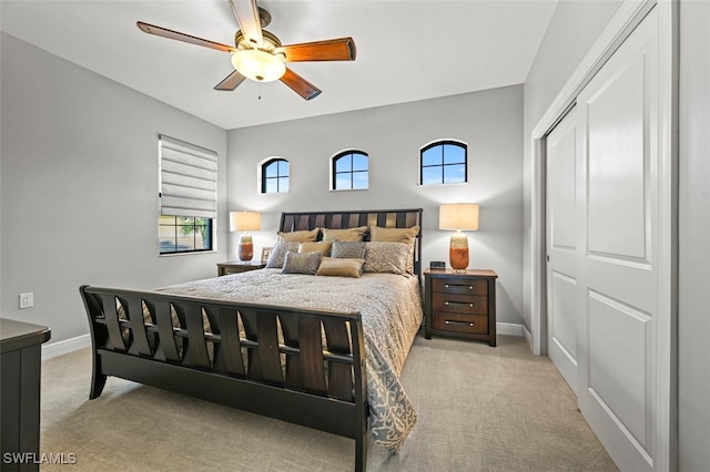 bedroom featuring a closet, ceiling fan, and light colored carpet