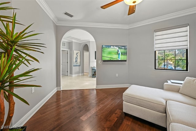 living area with ornamental molding, ceiling fan, and dark hardwood / wood-style flooring