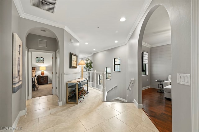 corridor with ornamental molding and light tile patterned flooring