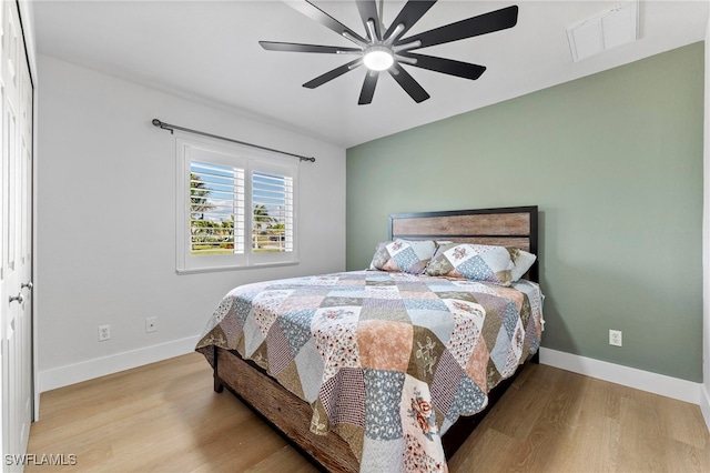 bedroom featuring baseboards, visible vents, and wood finished floors