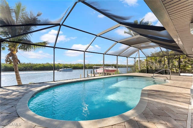 outdoor pool with a water view, a patio area, and glass enclosure