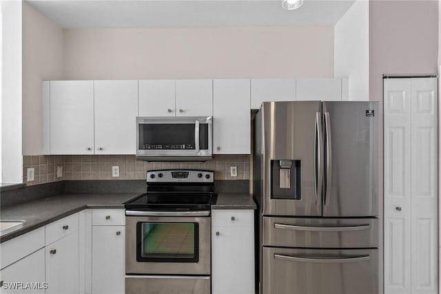 kitchen featuring stainless steel appliances, tasteful backsplash, and white cabinetry