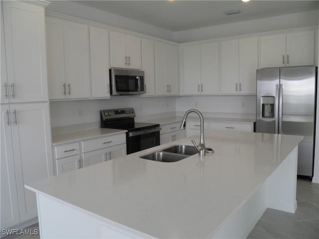 kitchen featuring white cabinetry, sink, stainless steel appliances, and a center island with sink