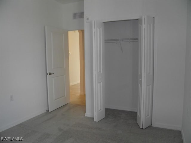 unfurnished bedroom featuring carpet and a closet