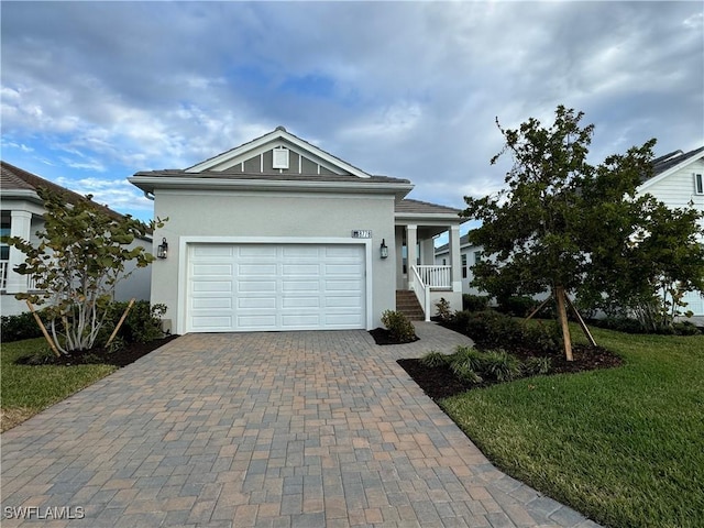 view of front of property with a porch, a front yard, and a garage