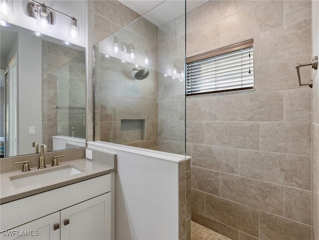 bathroom featuring vanity and tiled shower