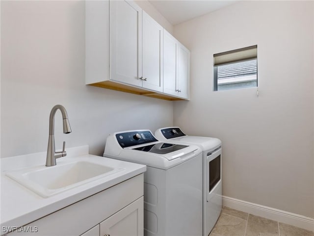 washroom with sink, light tile patterned floors, washing machine and dryer, and cabinets