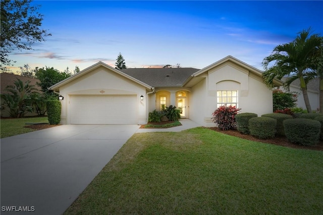 single story home with a garage and a lawn