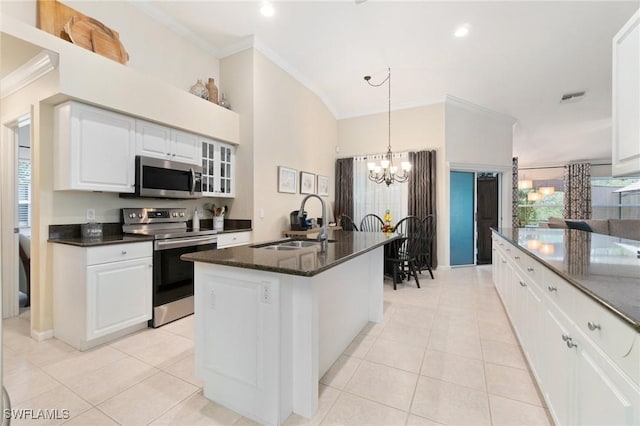 kitchen featuring white cabinetry, sink, light tile patterned floors, stainless steel appliances, and a center island with sink