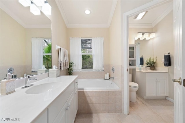 bathroom featuring tiled bath, ornamental molding, vanity, toilet, and tile patterned floors