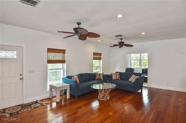 living room with ceiling fan and dark wood-type flooring