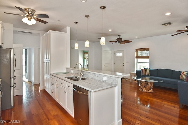 kitchen featuring white cabinets, decorative light fixtures, stainless steel appliances, sink, and light stone counters