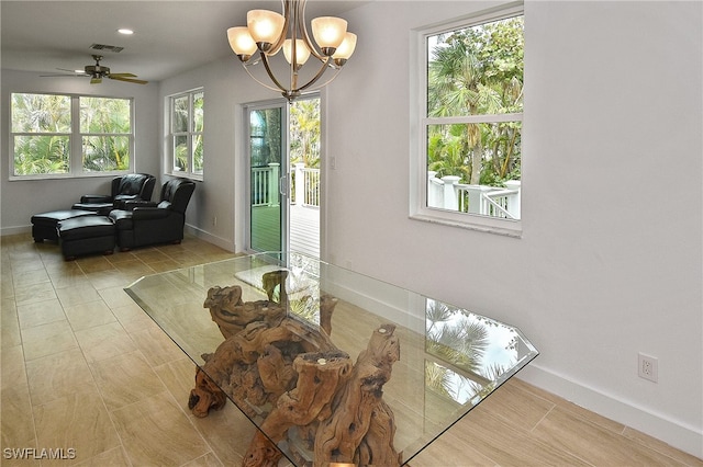 tiled dining area with ceiling fan with notable chandelier