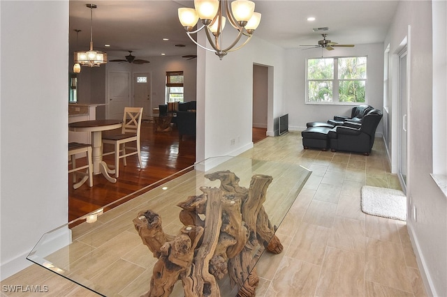 living room with ceiling fan with notable chandelier