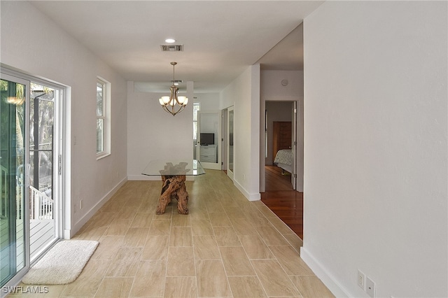 hall featuring an inviting chandelier