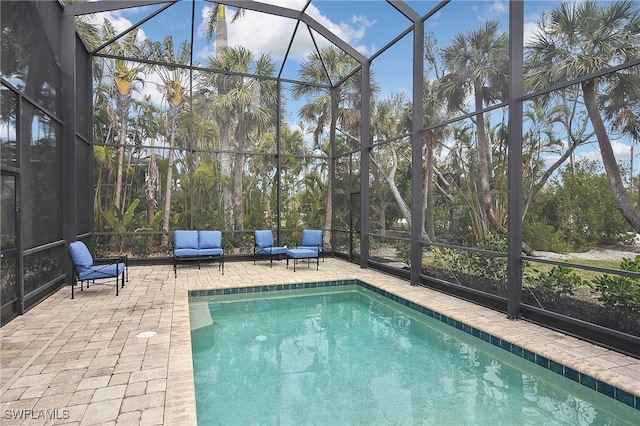 view of swimming pool featuring glass enclosure and a patio