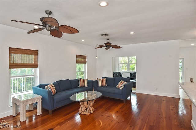 living room featuring ceiling fan and dark hardwood / wood-style flooring