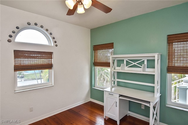 unfurnished office featuring ceiling fan, dark wood-type flooring, and plenty of natural light