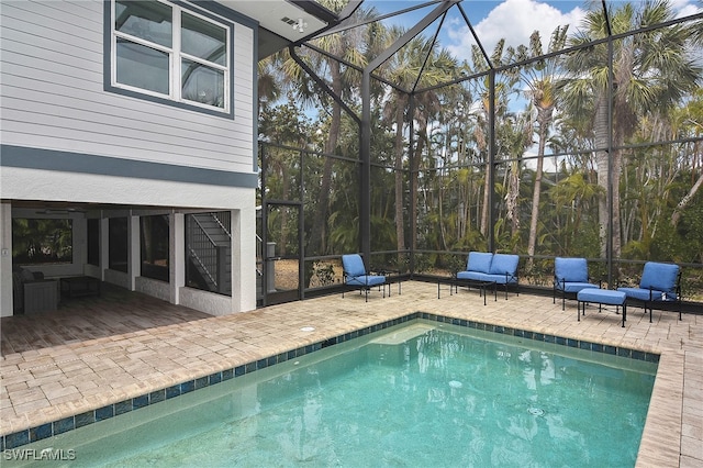 view of swimming pool with an outdoor hangout area, glass enclosure, and a patio area