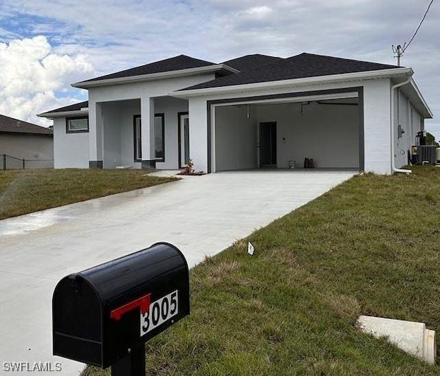 view of front of house featuring a front yard, a garage, and cooling unit