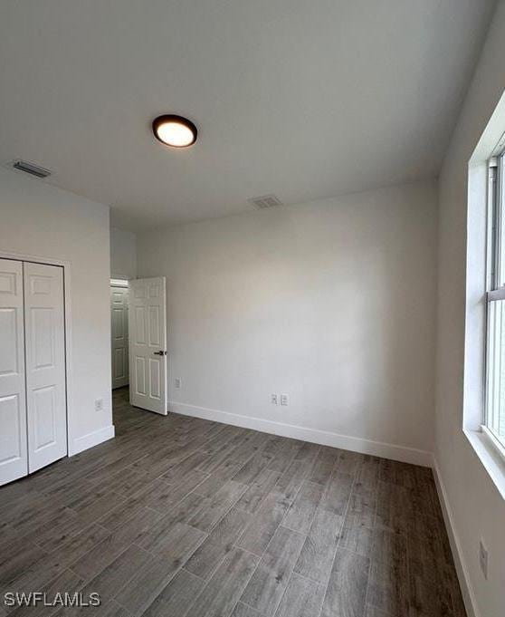 unfurnished bedroom featuring hardwood / wood-style flooring and a closet