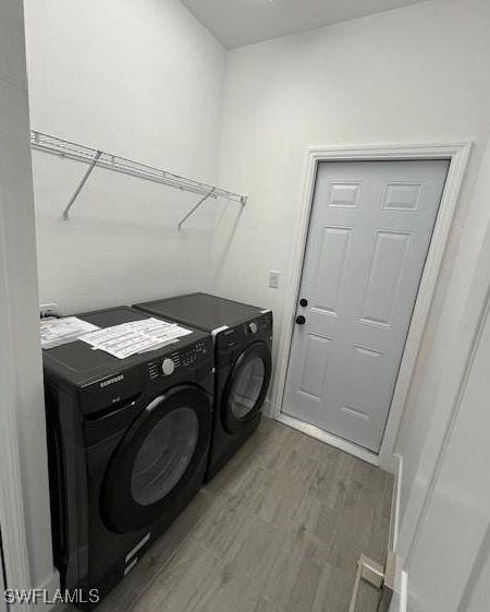 laundry room with independent washer and dryer and dark hardwood / wood-style flooring