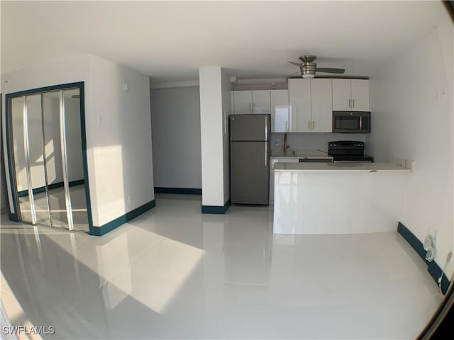 kitchen with stainless steel appliances, white cabinets, and ceiling fan