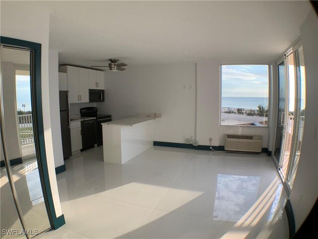 kitchen with white cabinetry, a water view, light tile patterned flooring, ceiling fan, and black appliances