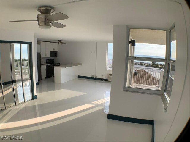 kitchen featuring white cabinets, ceiling fan, a wall mounted AC, and black appliances