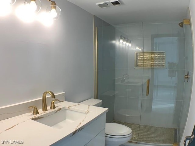 bathroom with walk in shower, vanity, and toilet