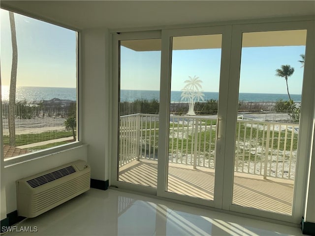 interior space with a water view, a healthy amount of sunlight, and a wall unit AC